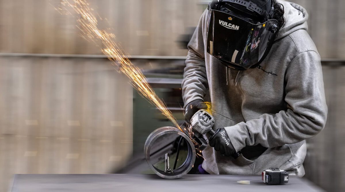person grinding metal with tool